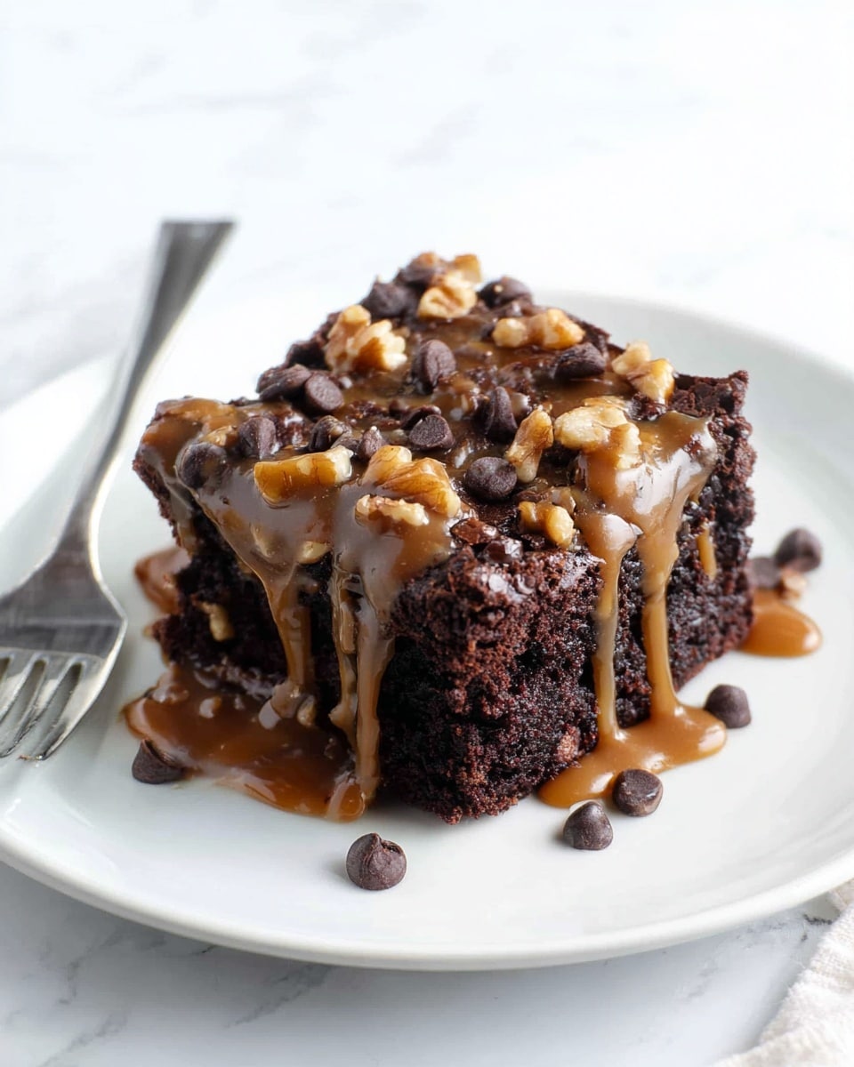 A dark brown chocolate cake sits inside a gray baking tray, with one square piece removed from the close corner. The cake has two visible layers; the bottom layer is a dense chocolate cake, and the top layer is thick and creamy, covered with a mix of toppings including light brown pecan nuts, dark brown chocolate chips, and thin strands of caramel spread over the surface. A black spatula rests inside the tray on the empty space where the piece was taken out, with some crumbs sticking on it. The tray is placed on a white marbled surface. photo taken with an iphone --ar 4:5 --v 7