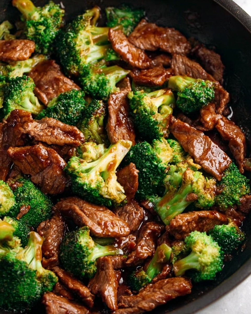 A stoneware bowl filled with white rice forms the base layer, topped with a thick, glossy dark brown sauce that coats tender beef strips and bright green broccoli florets evenly spread on top, creating a rich contrast of colors and textures. The bowl rests on a white marbled surface, with a pair of dark wooden chopsticks placed vertically to the left side of the bowl, adding to the presentation. The dish looks fresh and inviting with a balanced mix of colors and shapes. photo taken with an iphone --ar 4:5 --v 7