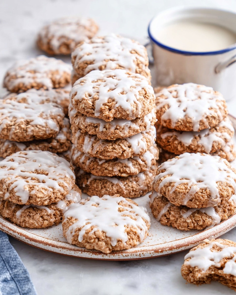 White platter filled with numerous freshly baked oatmeal cookies generously coated with a smooth white glaze, arranged in neat stacks and loose clusters showcasing their rustic texture, a small white bowl filled with additional glaze sits nearby, all placed on a white marble surface under soft natural lighting, professional food magazine style photo taken with an iphone --ar 4:5 --v 7