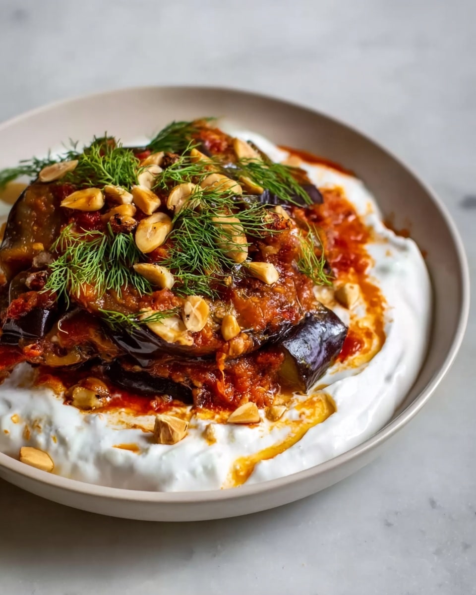 Large white shallow bowl filled with a generous serving of traditional Turkish manti dumplings smothered in rich tomato sauce and topped with creamy yogurt sauce, drizzled with vibrant red chili oil and sprinkled with fresh herbs, showcasing a complete portion presented in an inviting, hearty style, photographed from a 3/4 angle on a white marble countertop with natural lighting, professional food magazine hero shot, photo taken with an iphone --ar 4:5 --v 7