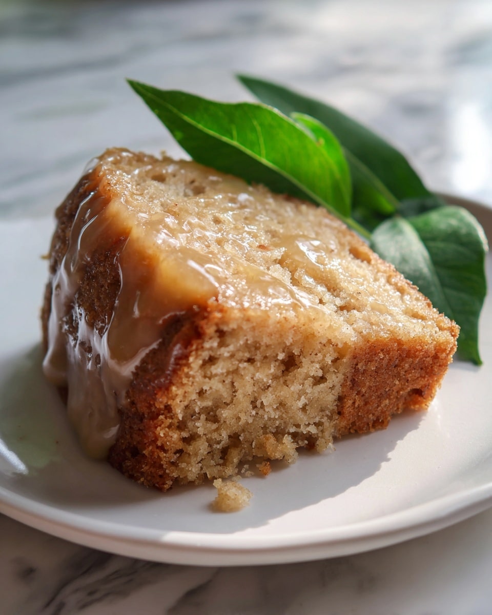 A whole rectangular cake glazed with a smooth, shiny icing that covers the entire top and edges, presented on a large white platter, with fresh green apples and leaves artfully arranged in the background. The cake’s edges are perfectly baked to a golden brown, showcasing a moist and dense texture. The scene is set on a white marble countertop, captured in natural light from a professional 3/4 angle to highlight the full uncut cake, styled as a glossy, appetizing hero food shot. Photo taken with an iphone --ar 4:5 --v 7