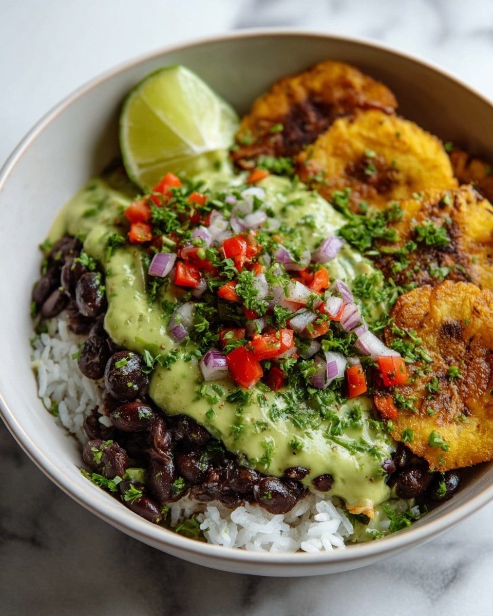 Large white bowl filled with a generous serving of seasoned black beans topped with finely diced red onions, red bell peppers, and fresh chives, accompanied by a row of golden, crispy tostones, garnished with fresh cilantro sprigs and thick, creamy avocado crema drizzles, and accompanied by a wedge of lime, all presented on a white marble surface with natural lighting, styled as a professional hero food shot from a 3/4 angle, photo taken with an iphone --ar 4:5 --v 7
