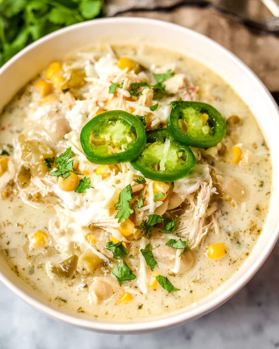 Large white bowl filled with creamy chicken and corn chowder featuring tender pieces of shredded chicken, whole corn kernels, diced vegetables, and rich broth, garnished with fresh herbs, multiple bowls arranged together on a white marble countertop, natural lighting capturing the comforting texture and vibrant ingredients, professional food styling photo taken with an iphone --ar 4:5 --v 7