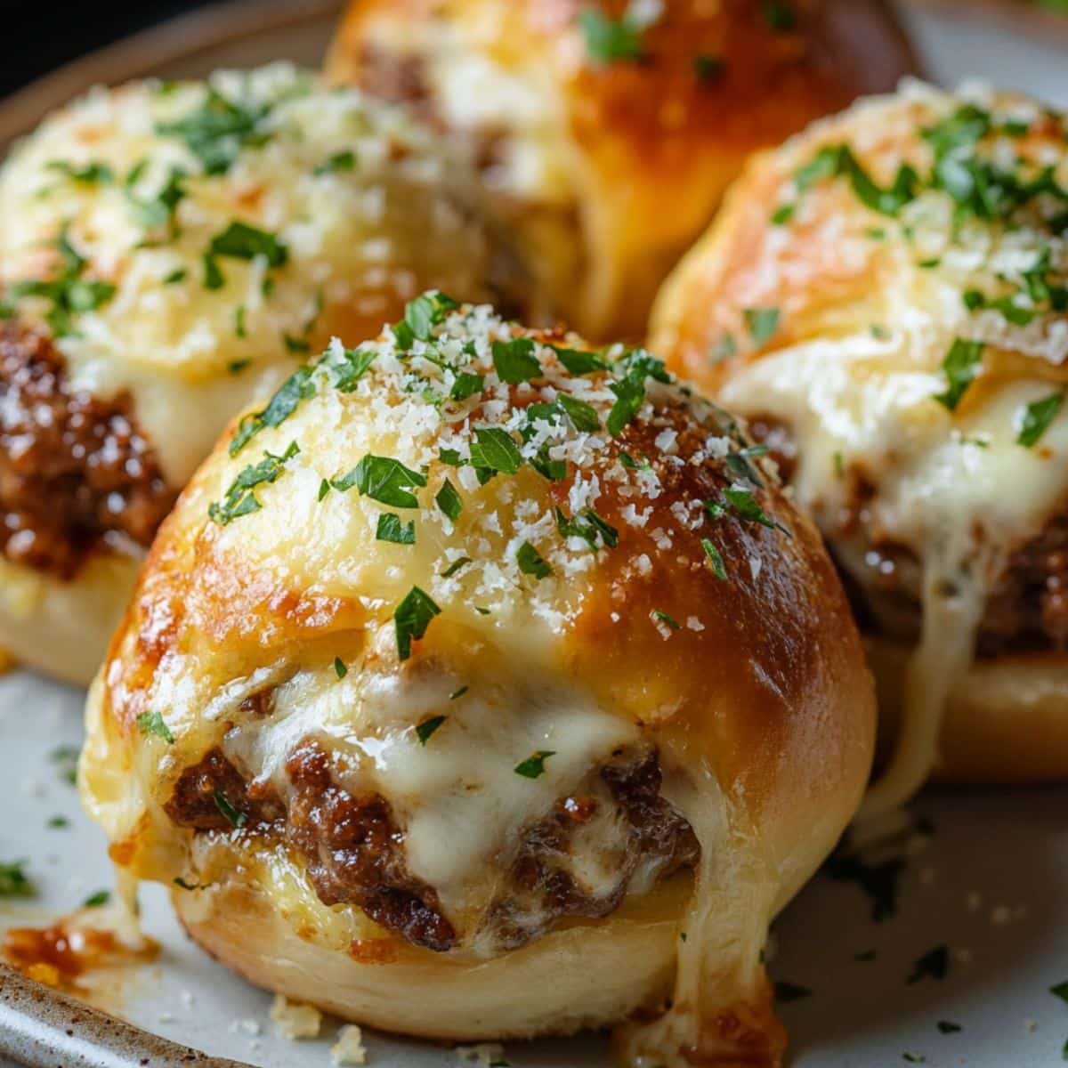Single white plate showcasing one serving of a golden-baked slider bun filled with rich, savory ground beef and generously melted white cheese oozing slightly over the sides, sprinkled with finely chopped fresh parsley and grated Parmesan cheese on top, close-up angled view emphasizing the soft interior texture of the bun and the juicy filling inside, natural lighting on white marble surface, styled like an individual portion ready to eat from a food blog, photo taken with an iphone --ar 4:5 --v 7