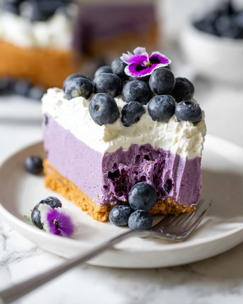 Whole, round blueberry cheesecake with vibrant purple filling on a golden graham cracker crust, topped with a generous layer of fresh blueberries and delicate edible purple and white flowers, served on a white plate, beautifully styled and photographed from a 3/4 angle, white marble background with natural lighting, professional food magazine hero shot photo taken with an iphone --ar 4:5 --v 7